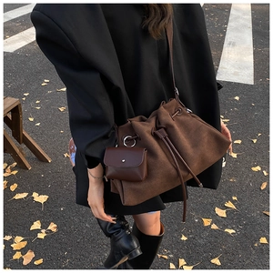 Detail of dark brown matte bucket bag with drawstring and matching hanging pouch detail
