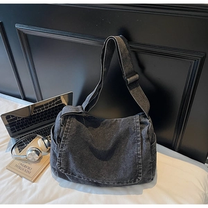 Vista dettagliata della borsa a tracolla in denim lavato con cinturino regolabile e tasca