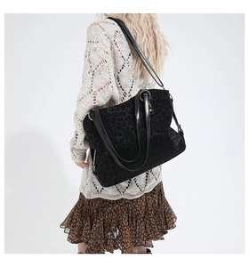Detail of large black leopard print tote bag in velvet fabric with glossy leather straps
