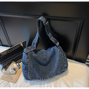Dettaglio borsa a tracolla in denim con spallina regolabile e ampie tasche laterali esterne