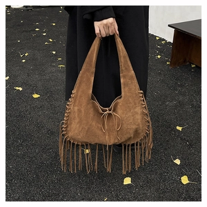 Bohemian suede tote bag detail featuring handcrafted weaving and long fringe tassels