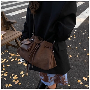 Detail of vintage chocolate brown suede bucket bag with drawstring and small pouch