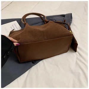 Gros plan détaillé du cabas en daim marron foncé avec contraste cuir et mini pochette