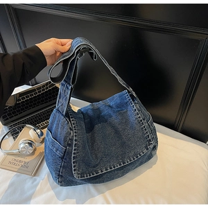 Dettaglio della borsa a tracolla in denim vintage con tracolla regolabile e tasca