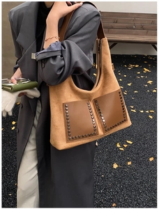 Nahaufnahme braune Wildleder-Tragetasche mit Vintage-Nieten und Fronttaschendetails