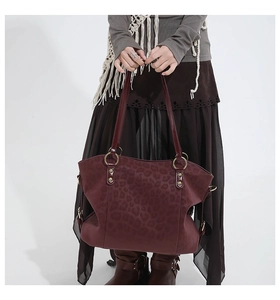 Close-up of burgundy leopard embossed faux leather tote bag with gold metal hardware