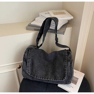 Dettaglio della borsa a tracolla in denim lavato con tracolla larga e tasche laterali