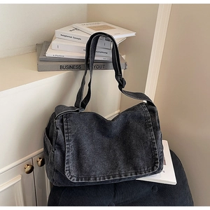 Dettaglio borsa a tracolla in denim grigio vintage con tracolla larga e tasche laterali