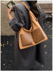 Streetstyle-Aufnahme einer großen braunen Hobo-Tasche aus Wildleder mit Vintage-Metallnieten
