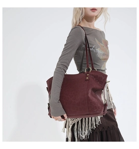Detail view of large burgundy leopard embossed tote bag styled with vintage maxi skirt