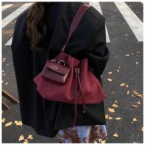 Detail of burgundy vintage tote bag featuring its unique matte texture and small pouch attachment