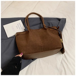 Détail du sac cabas en daim marron avec base en cuir et petite pochette zippée assortie