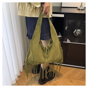 Detail of avocado green suede tote bag with long bohemian tassels and tie closure