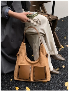 Detail der Vintage-Einkaufstasche aus braunem Wildleder mit schicken Retro-Nieten