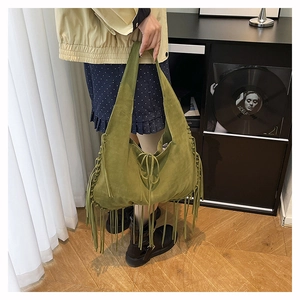 Detailed view of olive green suede hobo bag with long tassels and whipstitch edges