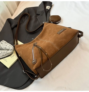 Detail of vintage brown suede tote bag with leather base and tassel zipper accessory