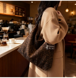 Detailed view of leopard print shoulder bag featuring metallic rivets and suede texture