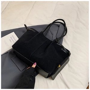 Détail du sac cabas en daim noir avec fermeture éclair dorée et empiècements en cuir lisse