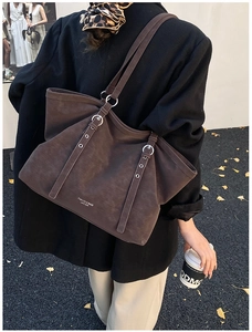 Detailed macro of dark brown matte leather tote bag with silver buckles and logo