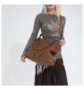 Detail view of large brown suede tote bag with leopard print texture and metal buckles