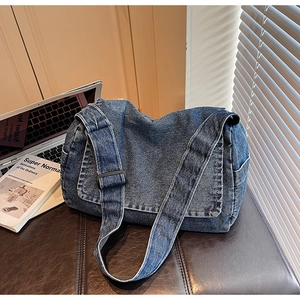 Dettaglio della borsa a tracolla in denim blu lavato con tracolla regolabile e tasca laterale