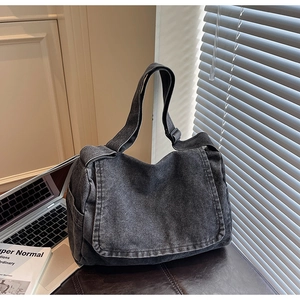 Vista dettagliata della borsa a spalla in denim nero lavato con texture vintage