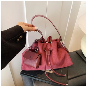 Detail view of burgundy bucket bag with drawstring closure and matching small pouch