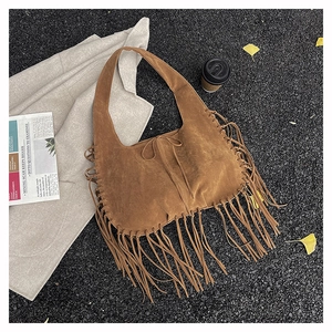 Close-up of brown suede hobo bag with long fringe detailing and bohemian tassel elements