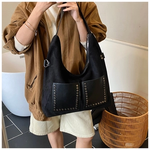 Detail der schwarzen matten Totebag mit Metallnieten und seitlicher Metallschnalle