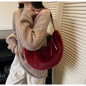 Détail du sac hobo en peluche rouge avec texture douce et fine bandoulière en cuir