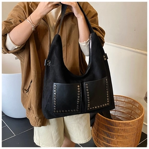 Detail der schwarzen Hobo-Tasche aus Wildleder mit Vintage-Nieten und Ledertasche