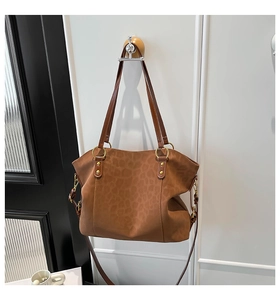 Detailed close-up of brown leopard print leather tote bag with elegant gold metal ring hardware
