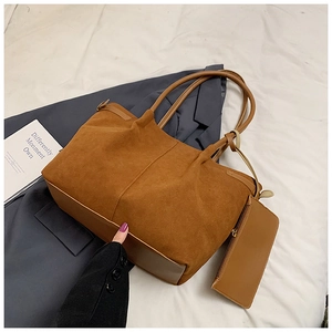 Détail d'un grand sac cabas en daim marron avec coutures et une pochette zippée assortie