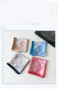 Detailed view of four elegant polka dot silk scarves in grey blue orange and pink