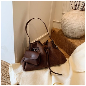 Detail view of brown suede bucket bag with leather drawstring and matching coin purse