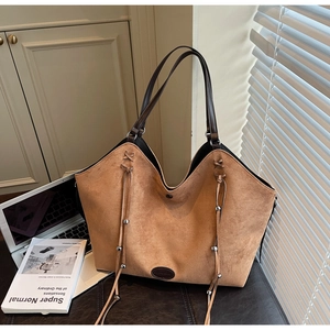 Vue détaillée du sac cabas en daim marron avec pampilles à franges et perles métalliques