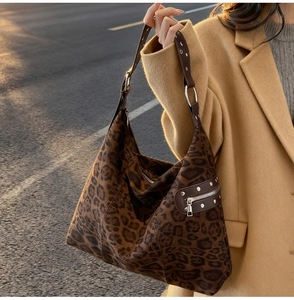 Detail of leopard print tote bag with silver rivets and zipper on soft suede material