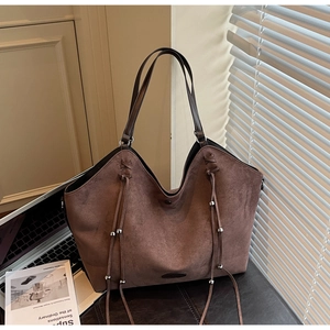 Détail du grand sac cabas en daim marron foncé avec pompons à franges et perles