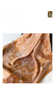 Vue détaillée du tissu de foulard en soie orange à motif paisley et texture lisse