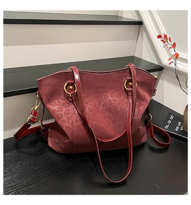 Detailed close-up of wine red leopard print tote with sleek leather handles and gold rings