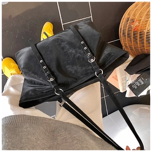 Detail view of black tote bag with vintage leather texture and silver metal eyelets