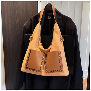 Detail der Vintage-Wildledertasche mit Nieten, Fronttaschen und breitem Schultergurt