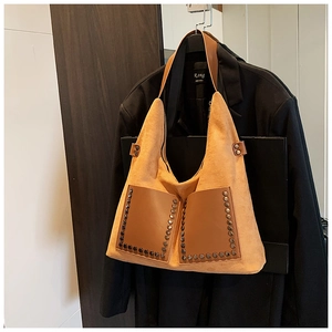 Detail der Vintage-Nietentasche mit braunen Lederfronttaschen und mattem Camel-Finish