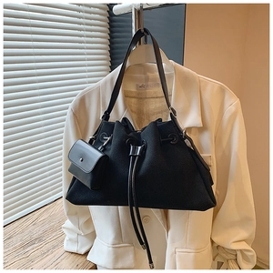 Detail of black drawstring tote bag with small matching pouch on a white blazer