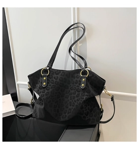 Detailed view of the black leopard print tote bag with gold metal buckles and studs