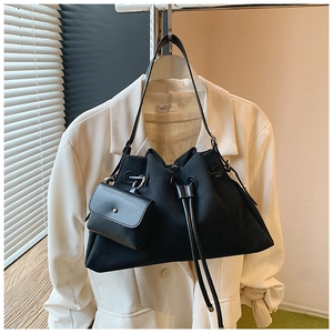 Close-up of minimalist black matte tote bag with small magnetic flap coin purse detail