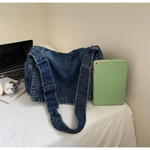 Dettaglio della grande capacità della borsa di jeans vintage con tablet per riferimento