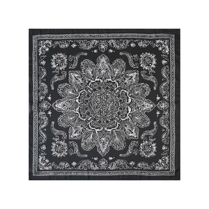 Gros plan d'un bandana carré aux motifs cachemire et mandala blancs sur tissu noir