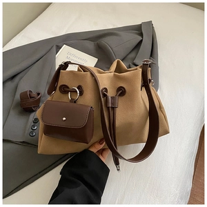 Close-up of khaki faux suede bucket bag with drawstring and detachable mini pouch