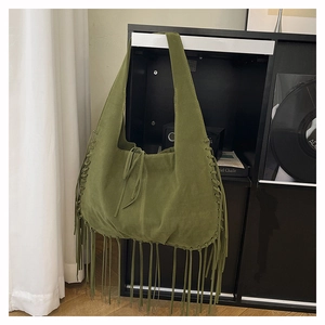 Detail view of olive green suede tote bag with long bohemian tassels and drawstring closure